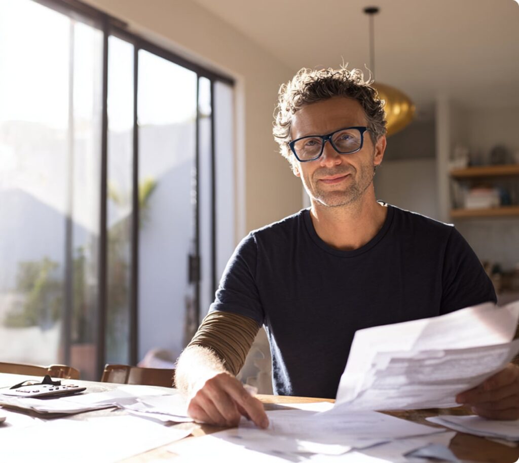 Homebuyer reviewing paperwork on dining table